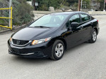 Black 2015 Honda Civic LX parked on the road, showcasing its clean exterior and modern design.