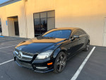 2012 Mercedes-Benz CLS550 4MATIC AWD in black with cream leather interior, parked outside.