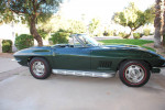 1967 Chevrolet Corvette convertible, restored, green exterior with chrome detailing, parked on driveway.