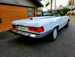 1986 Mercedes 560SL convertible parked outside, featuring a clean design and classic styling with low mileage.