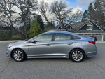 2015 Hyundai Sonata in great condition parked on a street, showcasing its sleek design and shiny exterior.