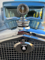 Close-up of a classic 1930 Plymouth Sedan hood ornament and grill, showcasing vintage automotive craftsmanship.