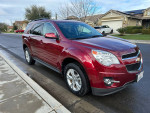 2010 Chevrolet Equinox in red, parked on the street, showcasing its stylish design and alloy wheels.
