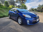 2011 Toyota Prius One in blue, parked on the street, showcasing alloy wheels and sleek design.