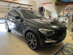 2019 BMW X3 parked in a garage, showcasing clean title and meticulous maintenance with panoramic moon roof.