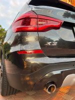 Rear view of a 2019 BMW X3 with clean title and meticulous maintenance, showcasing the sleek design and tires.