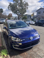 2019 Volkswagen e-Golf in Atlantic Blue parked on the street, featuring low mileage and a sleek design.