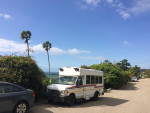 1997 Ford E-350 bus parked by the ocean, showcasing its low mileage and recent repairs for sale.