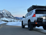 2010 Lexus GX 460 4WD parked on a snowy road with mountains in the background, showcasing its overland modifications.