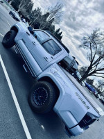 2021 Toyota Tacoma SR5 4WD in Cement color, parked, showcasing its off-road capabilities and sleek design.