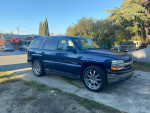 2002 Chevrolet Tahoe LT with 22-inch rims parked outdoors, showing clean lines and tinted windows.