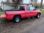 1998 Dodge Ram truck with engine issues, showing a solid body and minor dents, parked on a grassy area.