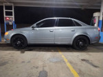 Side view of a silver 2007 Audi A4 Quattro parked at a gas station with black wheels.