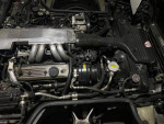 Engine compartment of a 1987 Chevy Corvette with rebuilt components and new accessories.