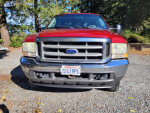 Front view of a 2002 Ford F250 Superduty XLT Crew in excellent condition, parked on gravel.