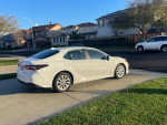2021 Toyota Camry in showroom condition parked on driveway, showcasing stylish design and minimal mileage.