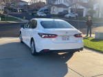 Rear view of a 2021 Toyota Avalon parked in front of a residential area with good lighting.