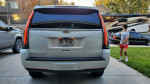 Rear view of a used 2017 Cadillac Escalade Platinum in Diamond White parked outside, showcasing LED taillights.