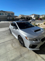 2016 Subaru WRX STI in silver parked in front of residential homes with clear blue sky