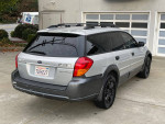 2005 Subaru Outback with low mileage, all-wheel drive, parked in front of a garage