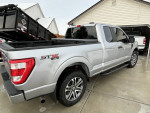 Silver Ford F-150 STX 4x4 with weather tech accessories and excellent condition parked in a driveway.