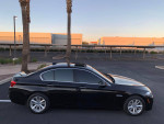 2015 BMW 5 Series 528i in black with sunroof parked under palm trees