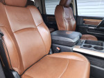Interior of a 2014 Ram 2500 Laramie showing brown leather seats and center console.