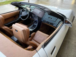 Interior view of a well-maintained 1990 Chevrolet Corvette convertible with brown leather seats.