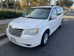 2010 Chrysler Town and Country Touring van in white with 139,000 miles, parked on street.
