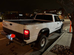 2002 Dodge Ram 2500 Cummins diesel truck in white, long bed, quad cab, parked at night.