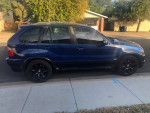 2005 BMW X5 4.8is AWD SUV with black leather interior, parked on the street, showing clean exterior and modern wheels.
