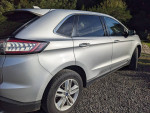Silver 2017 Ford Edge SEL FWD showcasing sleek design and sporty lines, parked in a natural setting.