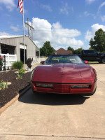 Front view of a 1987 Chevrolet Corvette parked outside, showcasing its classic design and original features.