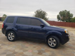 2014 Honda Pilot EX FWD in blue, parked on stone surface, good condition with 150k miles, salvage title.