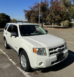 2012 Ford Escape Hybrid in white, low mileage, parked in an outdoor lot