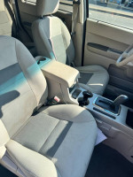 Interior view of a 2008 Ford Escape Hybrid with tan and gray seats, featuring a clean and well-maintained cabin.