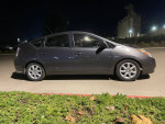 Side view of a 2010 Toyota Prius, a well-maintained hybrid car with 108,000 miles, parked at night.