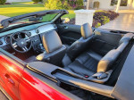 Interior view of a red 2007 Ford Mustang GT convertible with black leather seats and dashboard.
