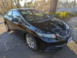 2014 Honda Civic LX in black, parked outdoors with sunlight, showcasing its sleek design and features.