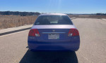 Rear view of a 2003 Honda Civic in good condition, featuring custom paint and new tires.