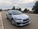 2019 Subaru Impreza in silver exterior parked on the street with a clear sky