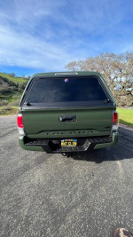 Rear view of a fully loaded 2022 Toyota Tacoma TRD Off Road 4WD with a high clearance camper shell.