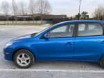 Side view of a blue 2011 Hyundai Elantra Touring GLS with low mileage, parked outdoors.