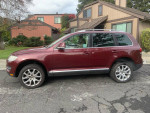 2008 Burgundy Volkswagen Touareg SUV parked outside, showcasing its elegant design and spacious body.