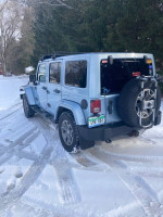 2012 Jeep Wrangler Unlimited Arctic Edition parked in snow, showcasing its removable hard-top and four-wheel drive features.
