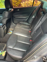 Interior view of a 2009 Nissan Maxima showing black leather back seats and floor mats.