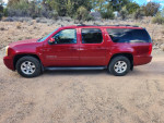 2013 GMC Yukon XL SLT RWD in red, parked on dirt road, showcasing power features and roof rack.