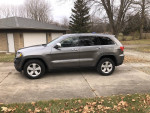 2012 Jeep Grand Cherokee 4x4 Limited in a residential driveway, showcasing its sleek design and modern features.