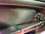 Close-up of the interior door panel of a 2015 Aston Martin V8 Vantage GT with leather and carbon fiber detailing.