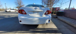 Rear view of a 2010 Toyota Corolla LE parked, showcasing new tires and a clean exterior.
